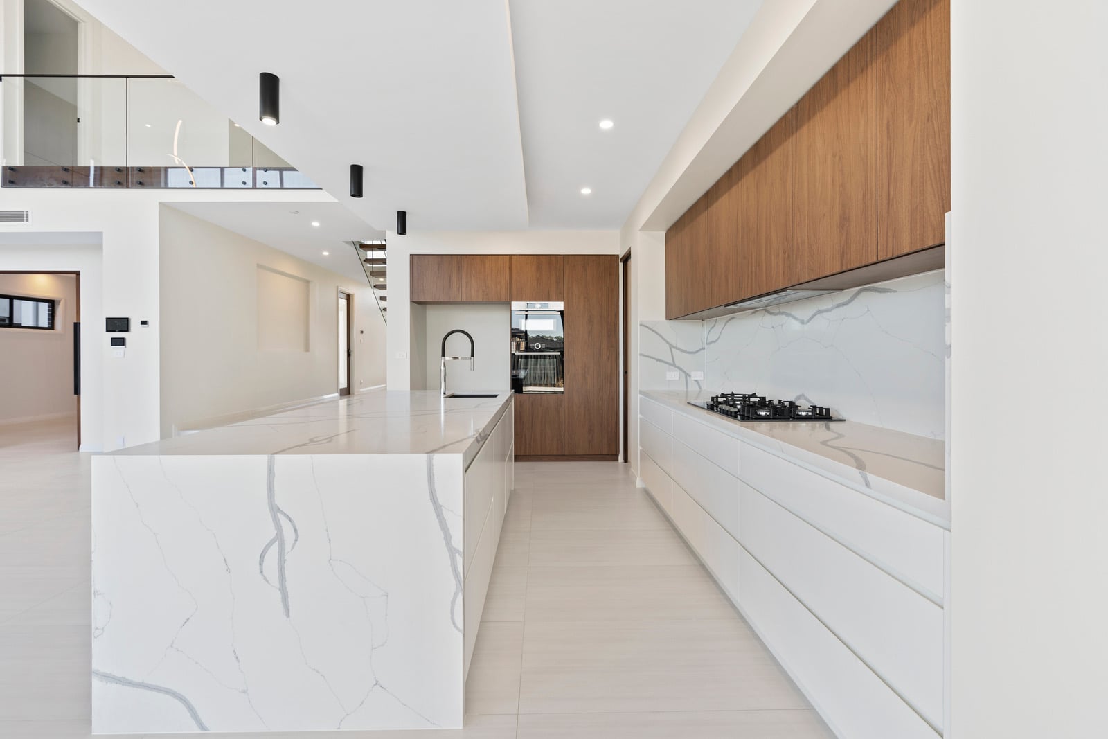Kitchen with marble island and concealed ducted air conditioning at Oran Park